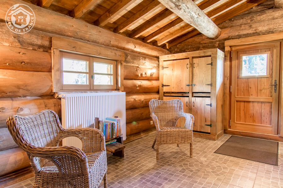 20 Douches & Lavabos 2 (Chalet Commun) Chalet en bois chaleureux avec fauteuils en osier et ambiance rustique.