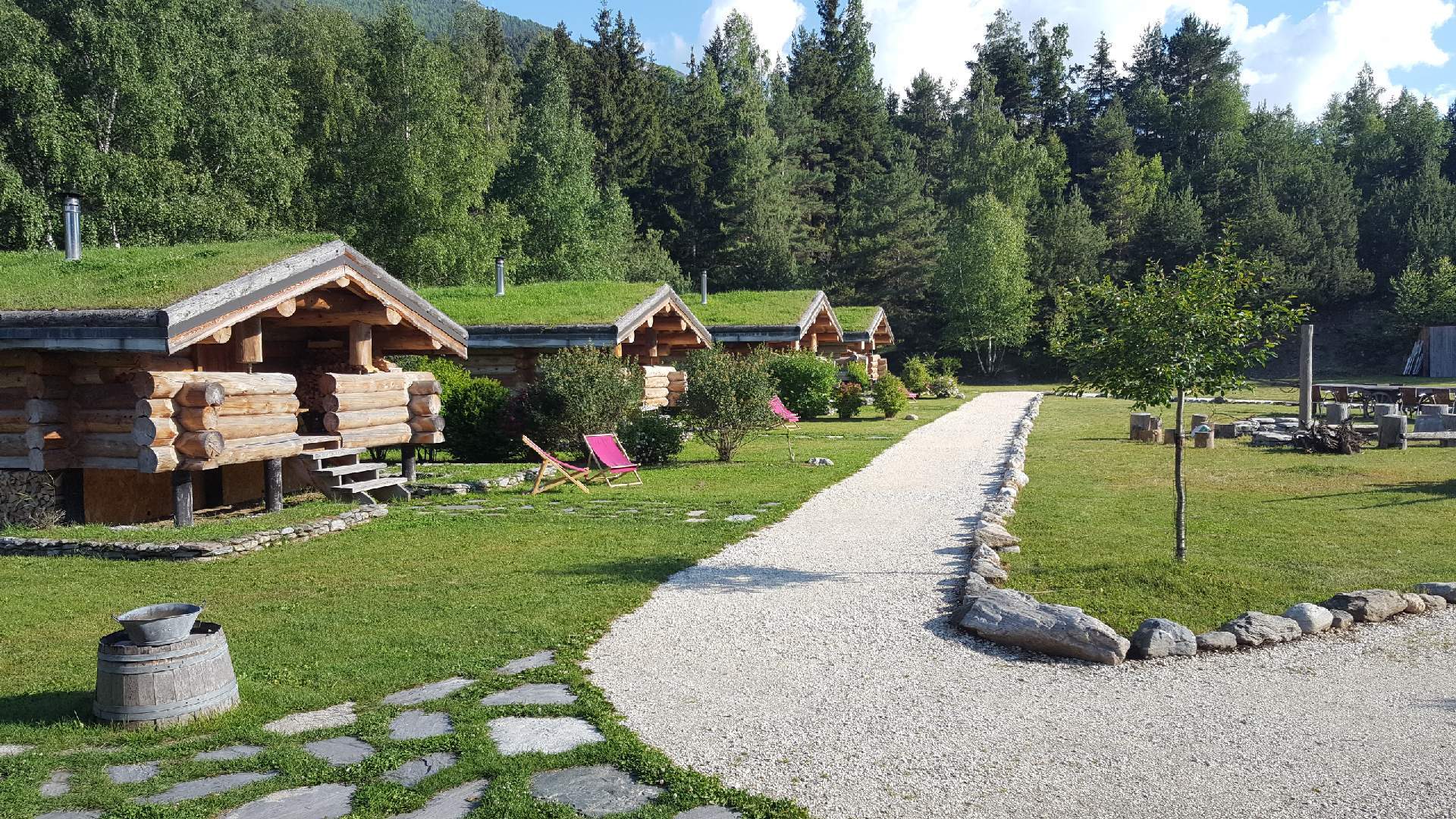 5 Les cabane au printemps Cabanes en bois avec toits végétalisés, entourées de verdure en Auvergne-Rhône-Alpes.