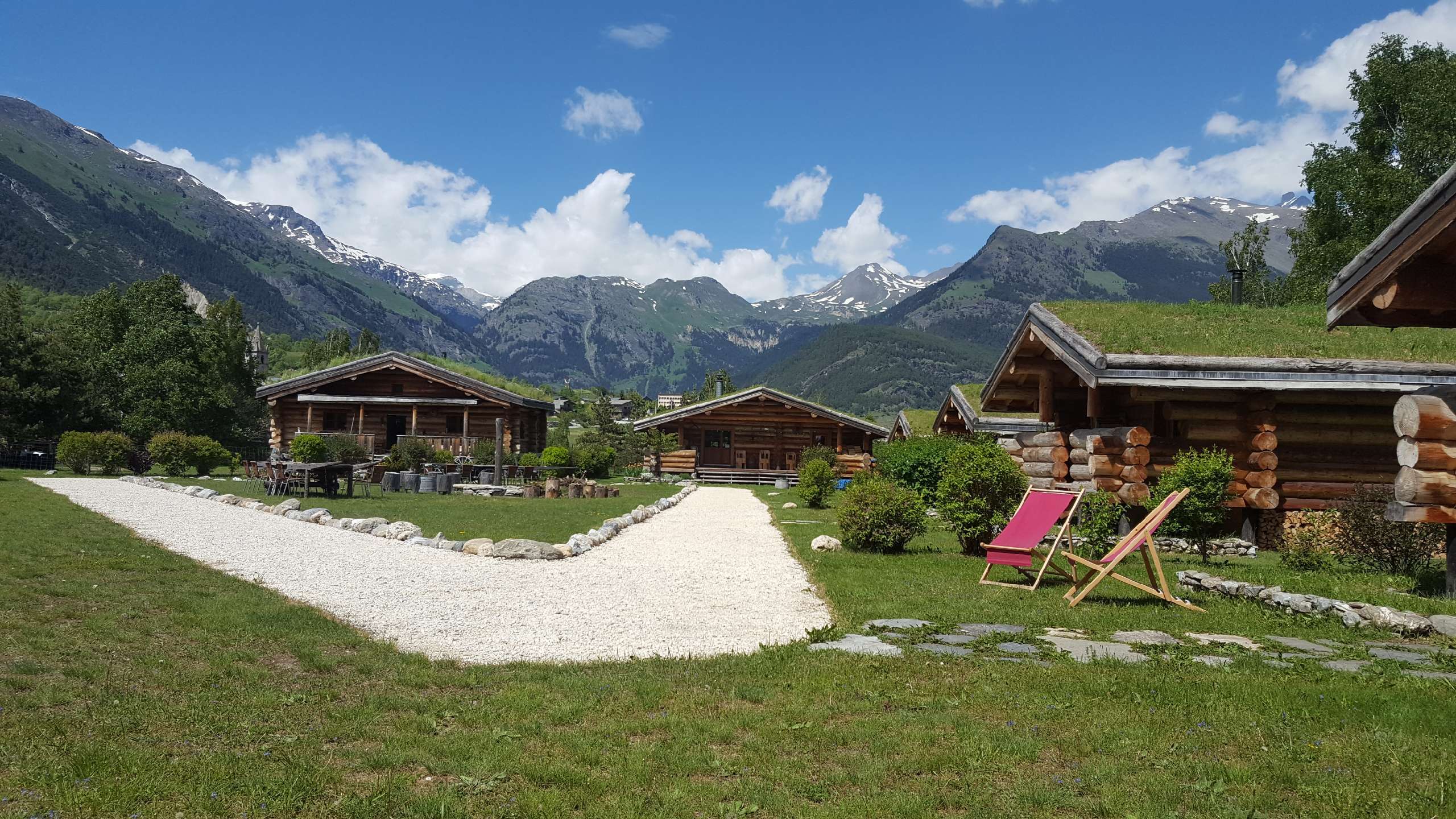 7 Le Parc National de la Vanoise au printemps Hébergement insolite en chalets en bois, avec vue sur les montagnes verdoyantes.