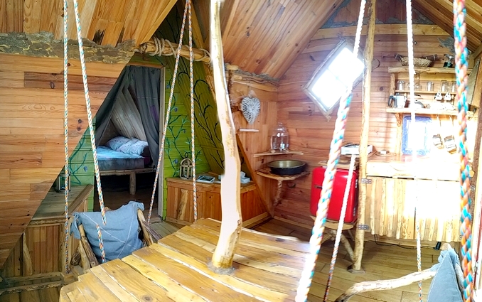 cahutte 2022 2 Cabane en bois avec intérieur chaleureux et balancelles, située en Basse-Normandie.