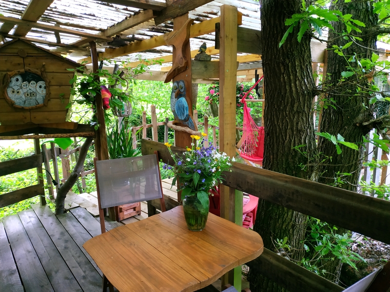 nid terrasse 2022 3 Hébergement insolite en cabane perchée, avec une terrasse bois et des fleurs décoratives.