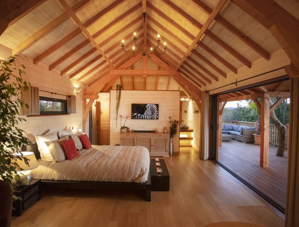 Chalet en bois avec poutres apparentes et vue sur la nature, idéal pour un séjour romantique.
