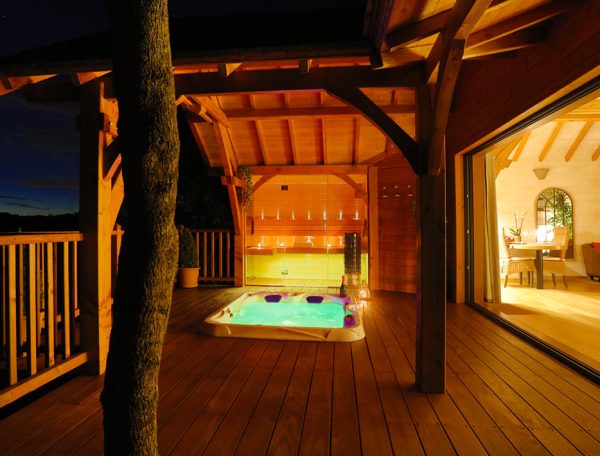 Cabane en bois avec jacuzzi, éclairage doux et vue sur la nature au Languedoc-Roussillon.