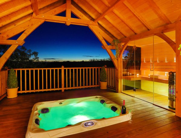 Cabane en bois avec jacuzzi, offrant une vue imprenable sur le coucher de soleil.
