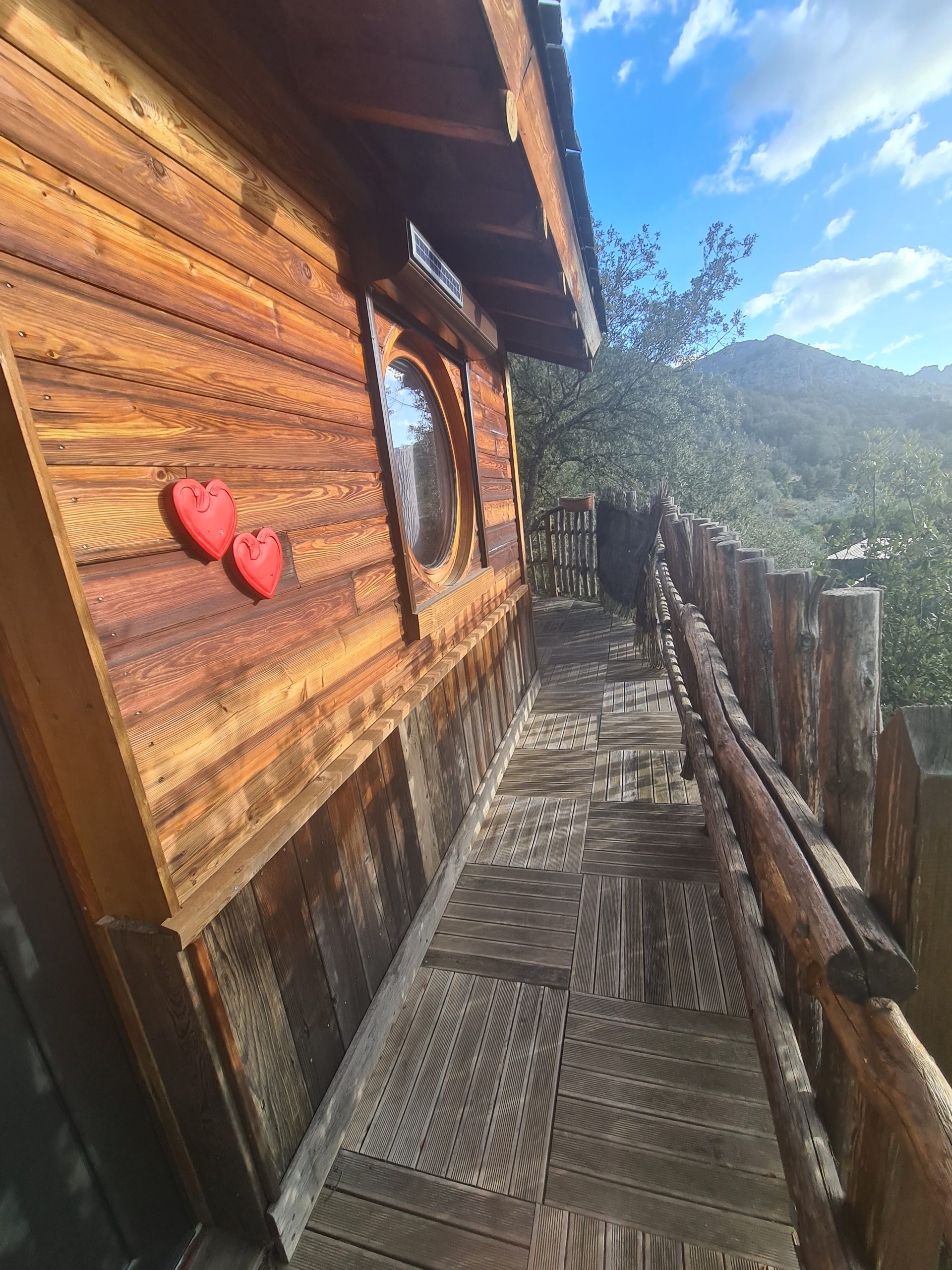 20220207_155807 (4) Cabane en bois en Corse avec un balcon et des cœurs décoratifs rouges.