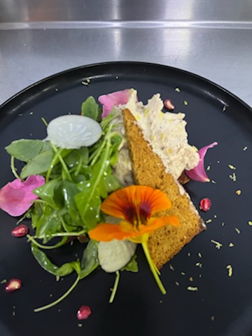 NQNK9704 Plat gourmet avec salade fraîche et fleur comestible, dans un hébergement insolite.