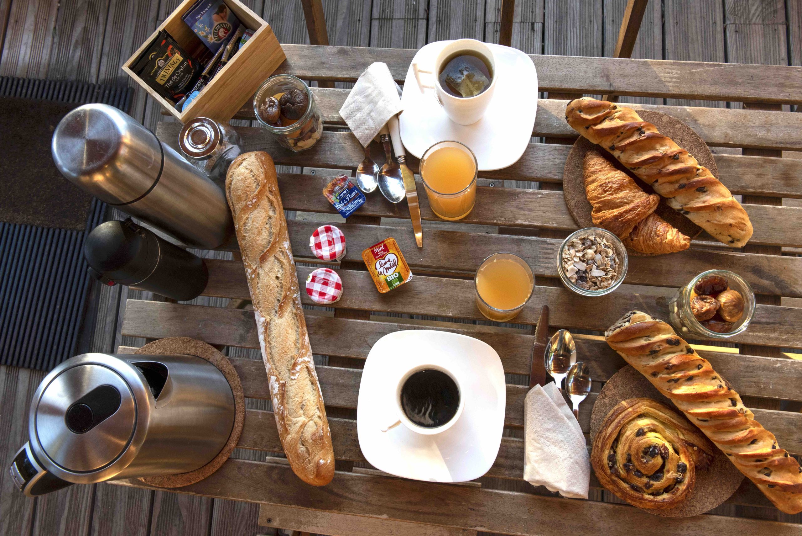 Petit déjeuner toutes cabanes moyenne def Petit-déjeuner copieux dans un hébergement insolite en Hauts-de-France, sur une table en bois.