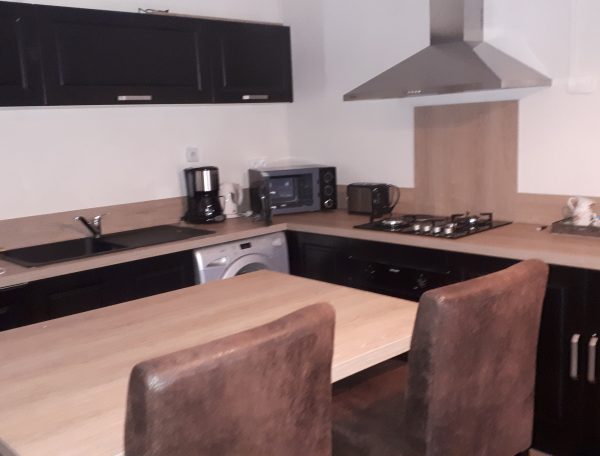 Cuisine moderne dun hébergement insolite en Grand-Est, avec table et chaises confortables.