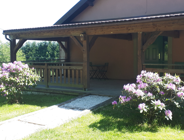 Hébergement insolite en bois avec terrasse, entouré de fleurs colorées à Grand-Est.