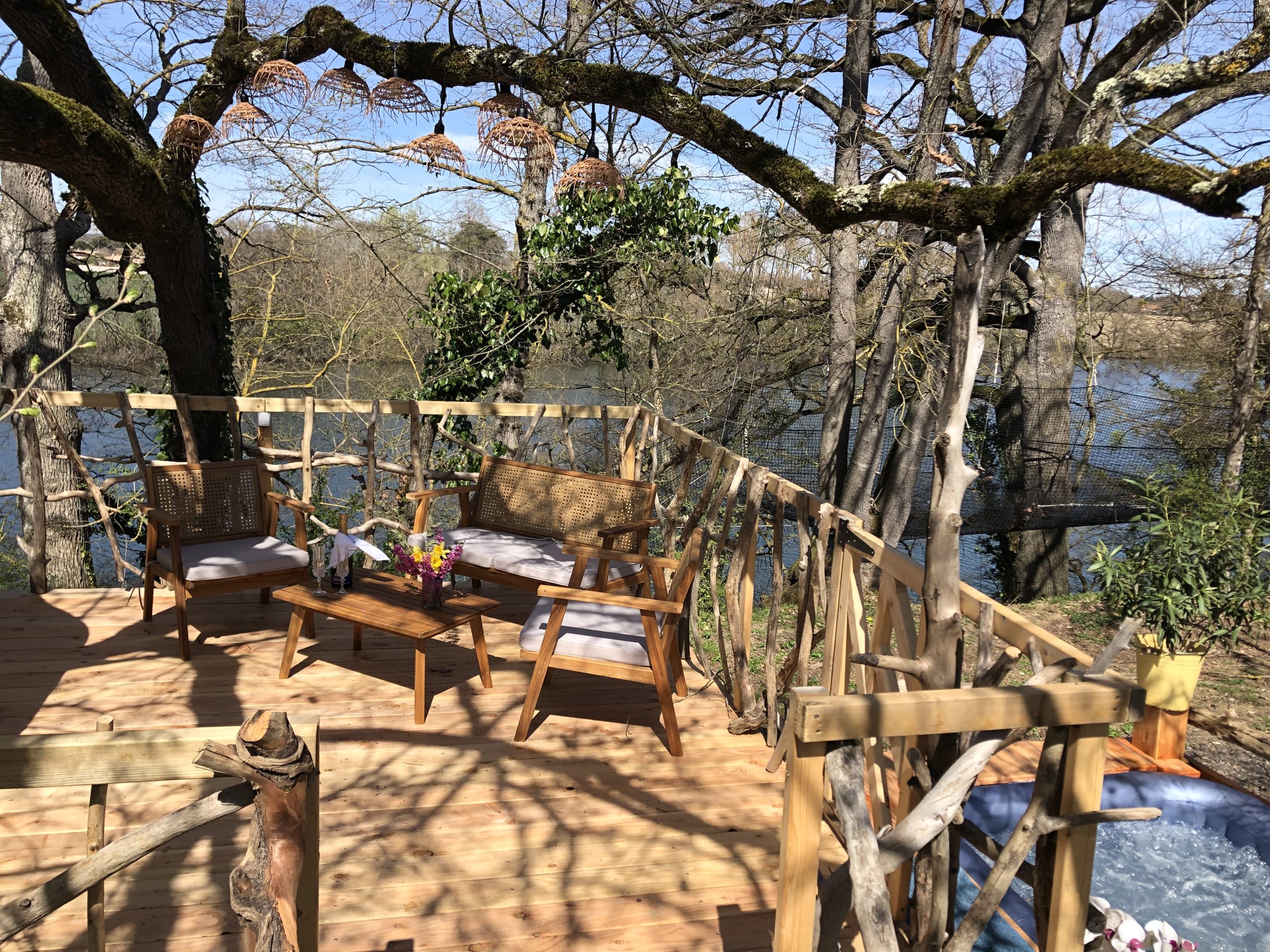 IMG_0787 Cabane perchée en bois avec terrasse, vue sur la rivière et mobilier en bois.