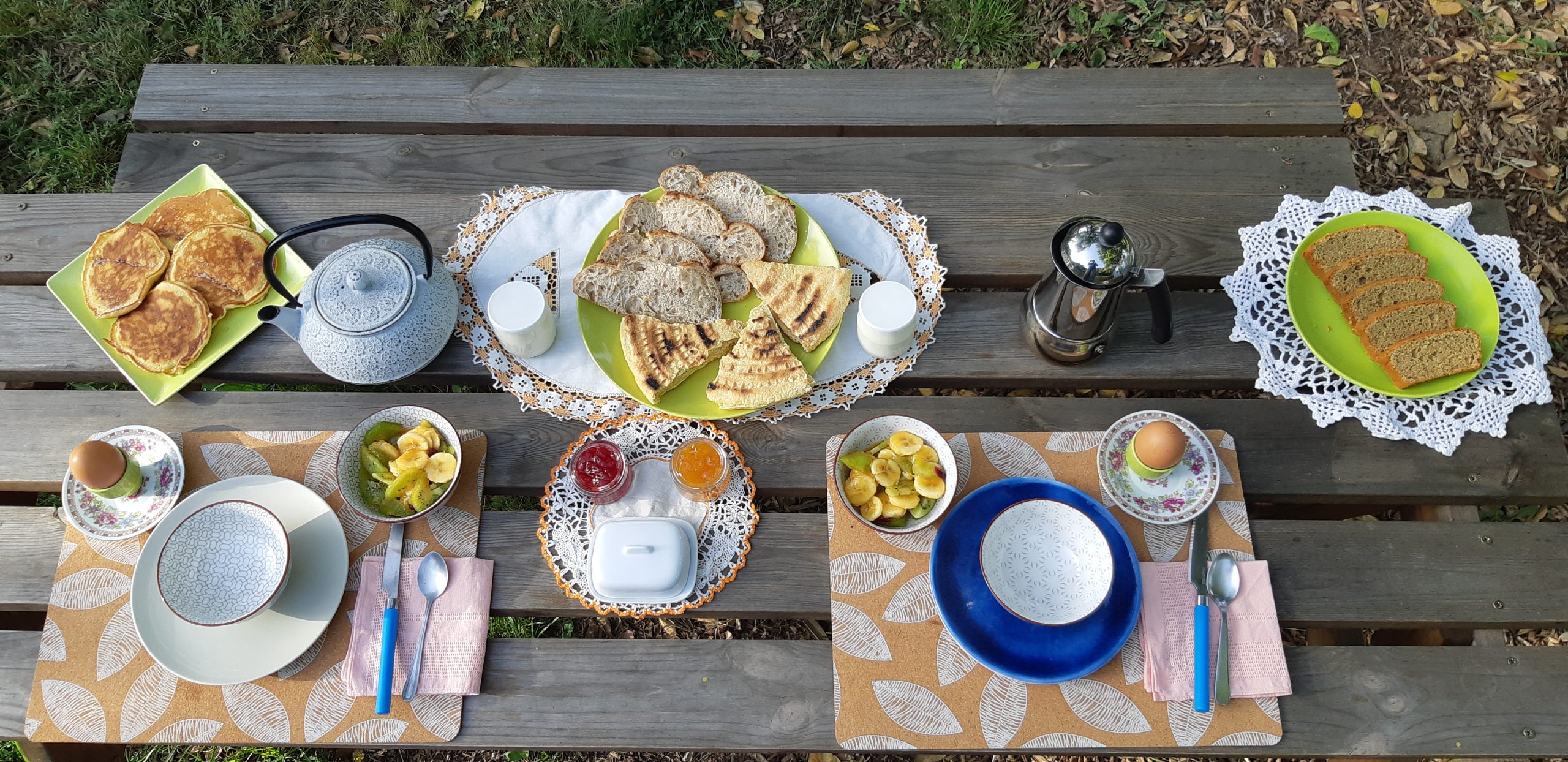 20220527_075450 Petit-déjeuner gourmand sur une table en bois, avec des crêpes et du pain frais.