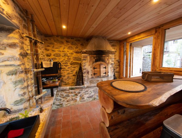 Hébergement insolite en Midi-Pyrénées : chalet en bois avec cheminée en pierre chaleureuse.