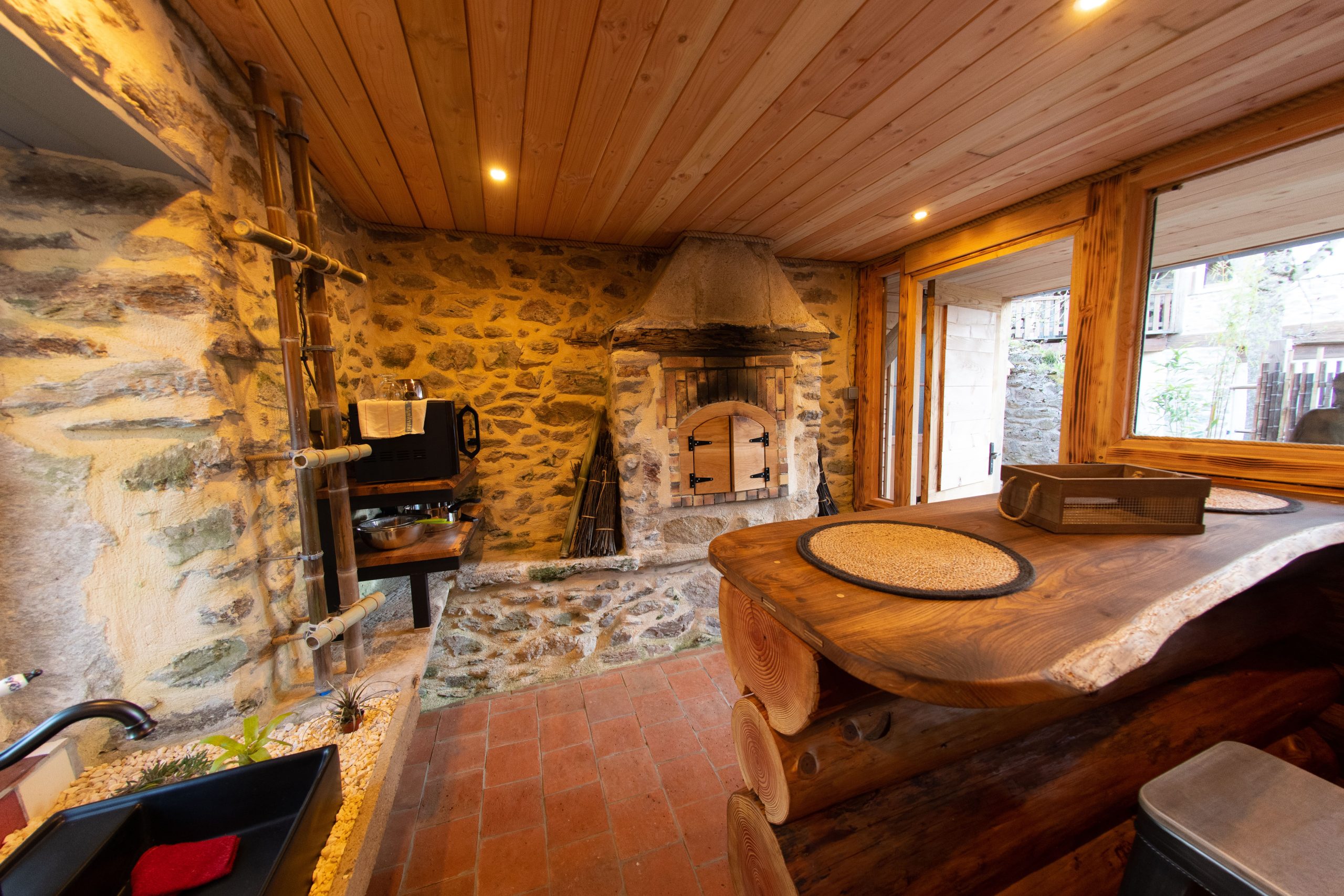 Hébergement insolite en Midi-Pyrénées : chalet en bois avec cheminée en pierre chaleureuse.
