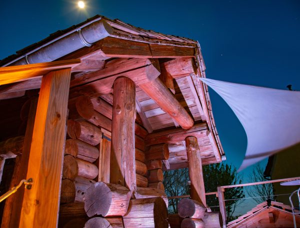 Cabane en bois dans les Midi-Pyrénées, illuminée sous la lune.