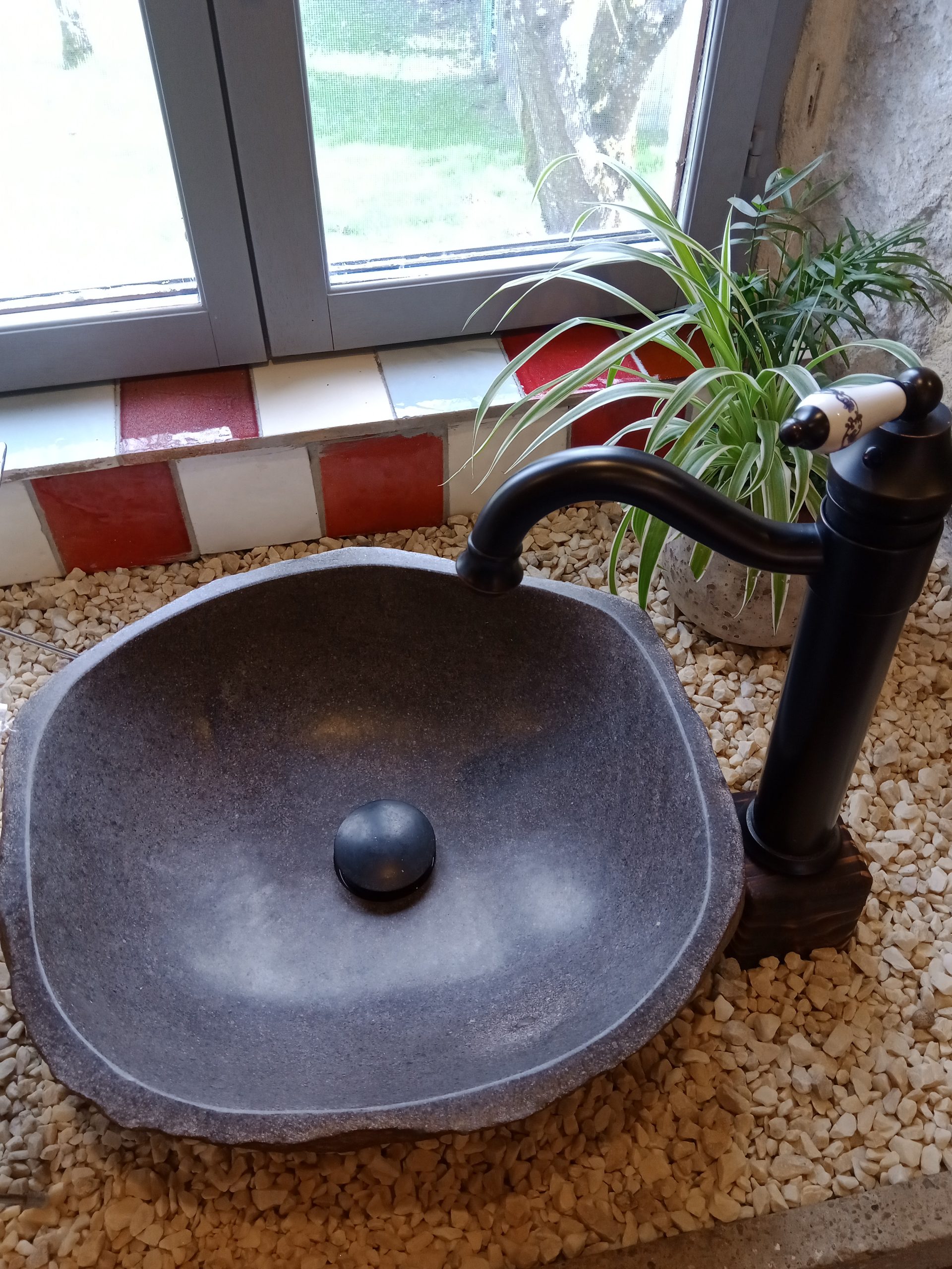 Évier en pierre naturelle dans un hébergement insolite en Midi-Pyrénées.