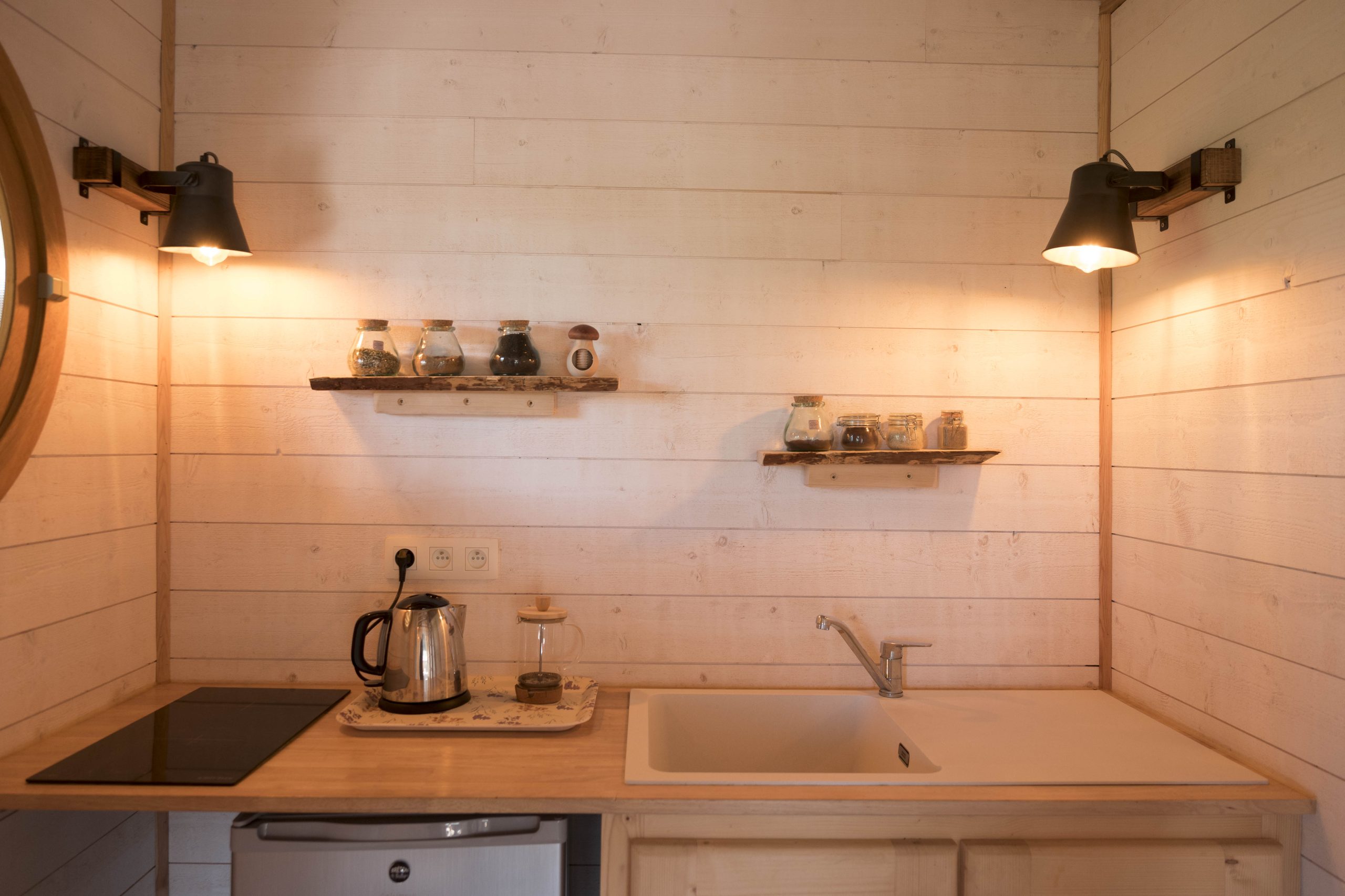 L1030759-3 Hébergement insolite en Bretagne : kitchenette en bois avec étagères décoratives.