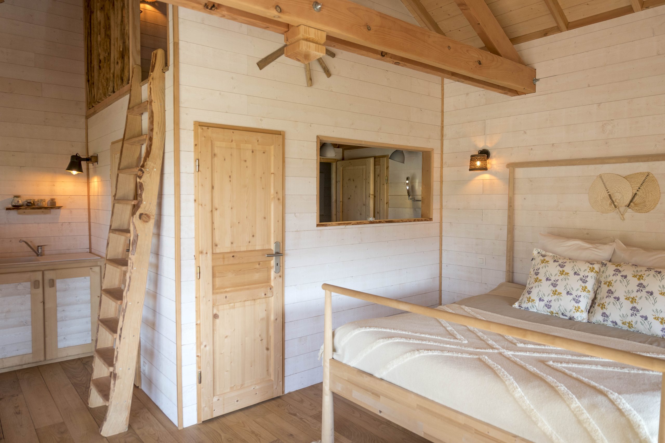 L1030802-2 Cabane en bois en Bretagne, intérieur lumineux avec lit douillet et échelle en bois.