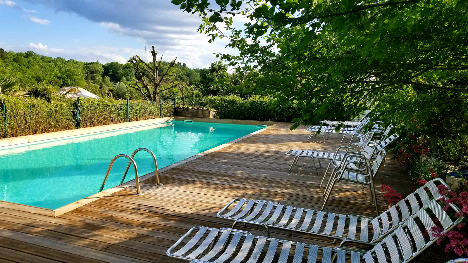 a piscine barjac insolite mai 2023 Hébergement insolite en Languedoc-Roussillon avec piscine et chaises longues en bois.