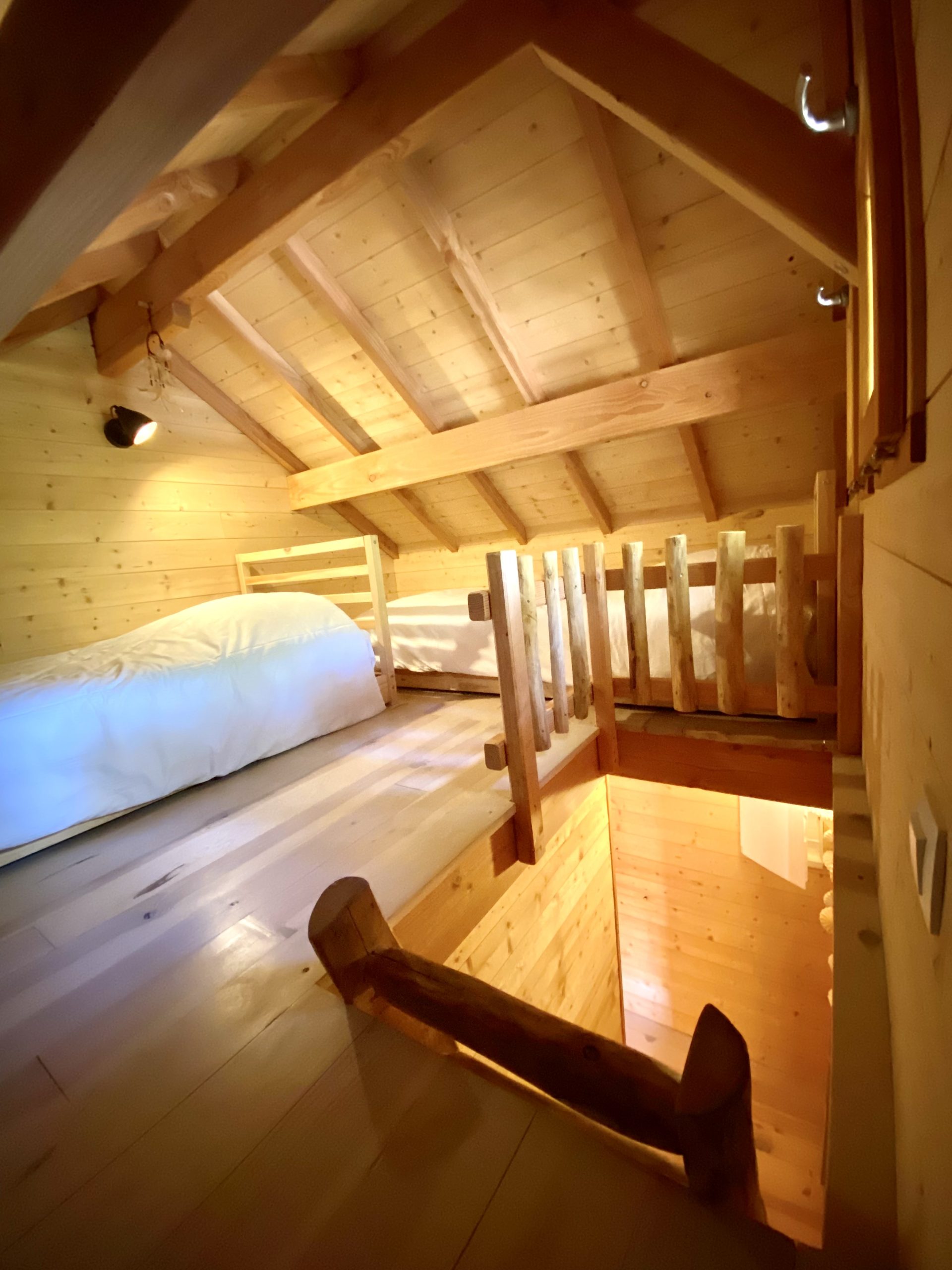 image00007-scaled Cabane en bois chaleureuse avec mezzanine et lumière douce, idéale pour un séjour unique.