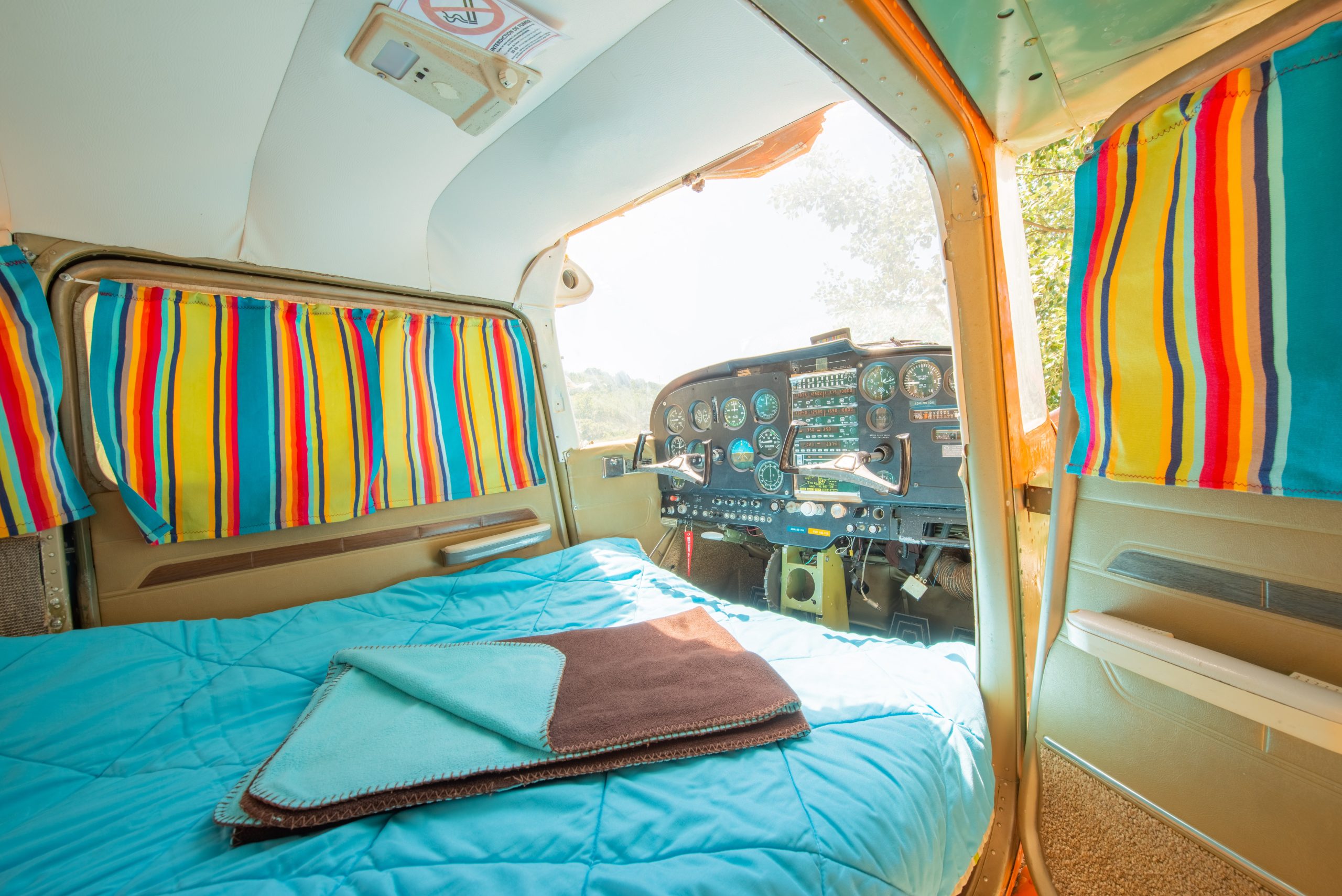 natura-lodge-21 Hébergement insolite : chambre dans un avion vintage avec rideaux colorés.