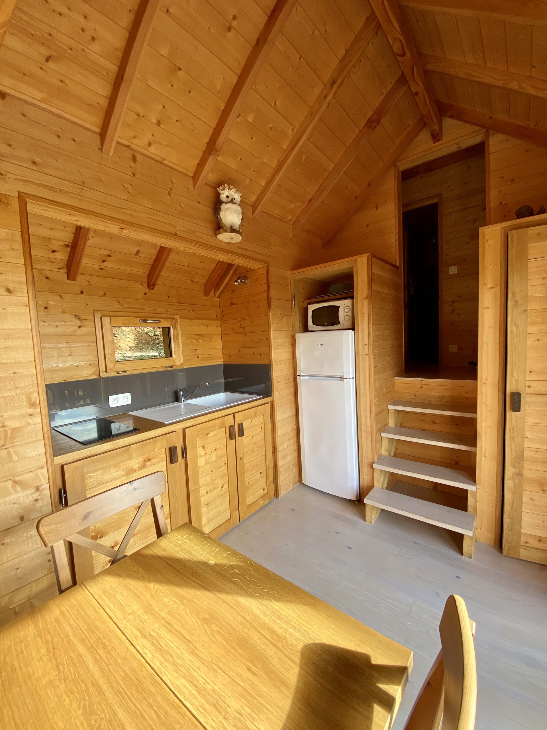surier-perchee-kitchen-scaled Cabane en bois chaleureuse avec cuisine équipée et escaliers en bois.