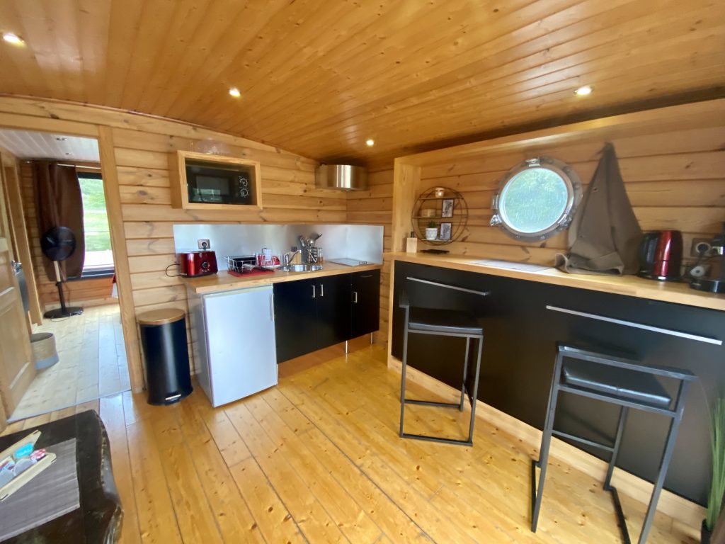 touespa5 Hébergement insolite en Auvergne : intérieur en bois chaleureux avec cuisine équipée.