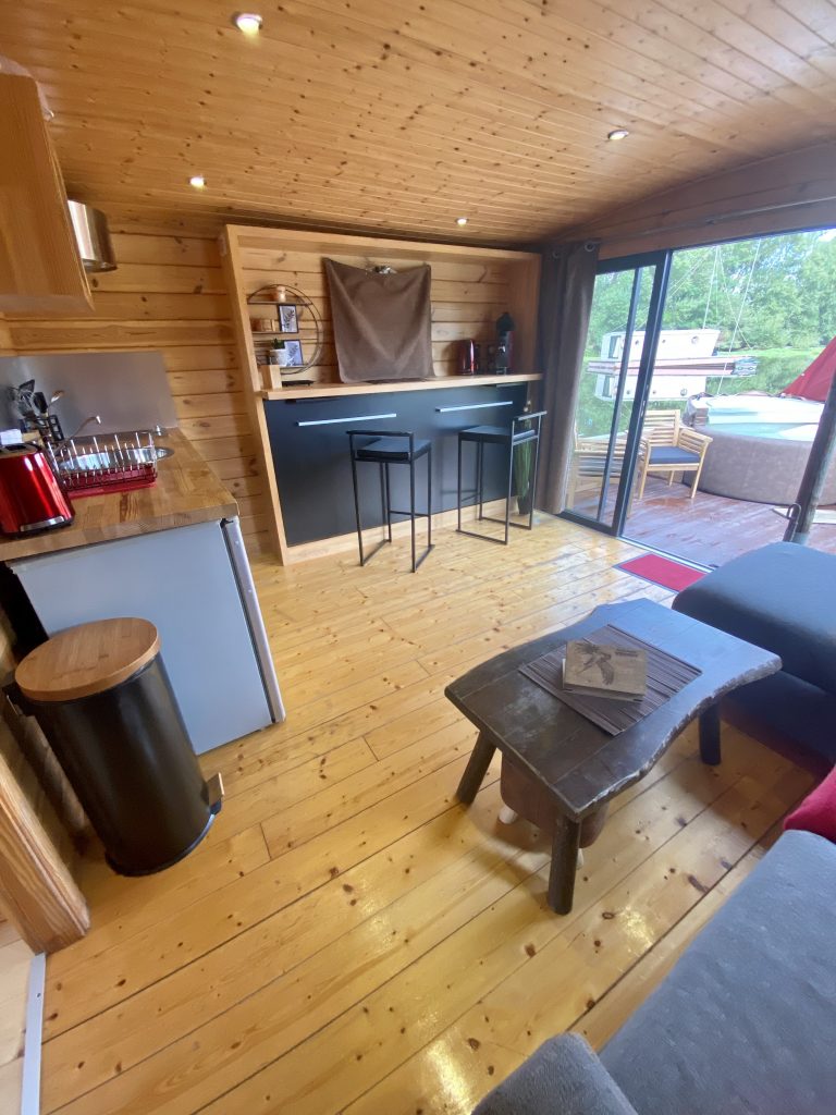 touespa9b Hébergement insolite en Auvergne : chalet en bois avec cuisine ouverte et vue sur la nature.