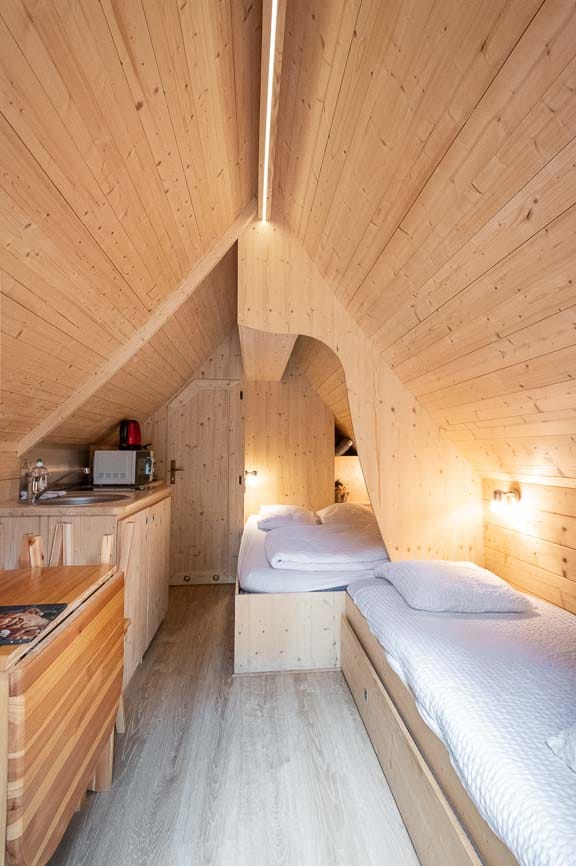 troll5 Chalet en bois à Champagne-Ardennes, intérieur chaleureux avec lit confortable.