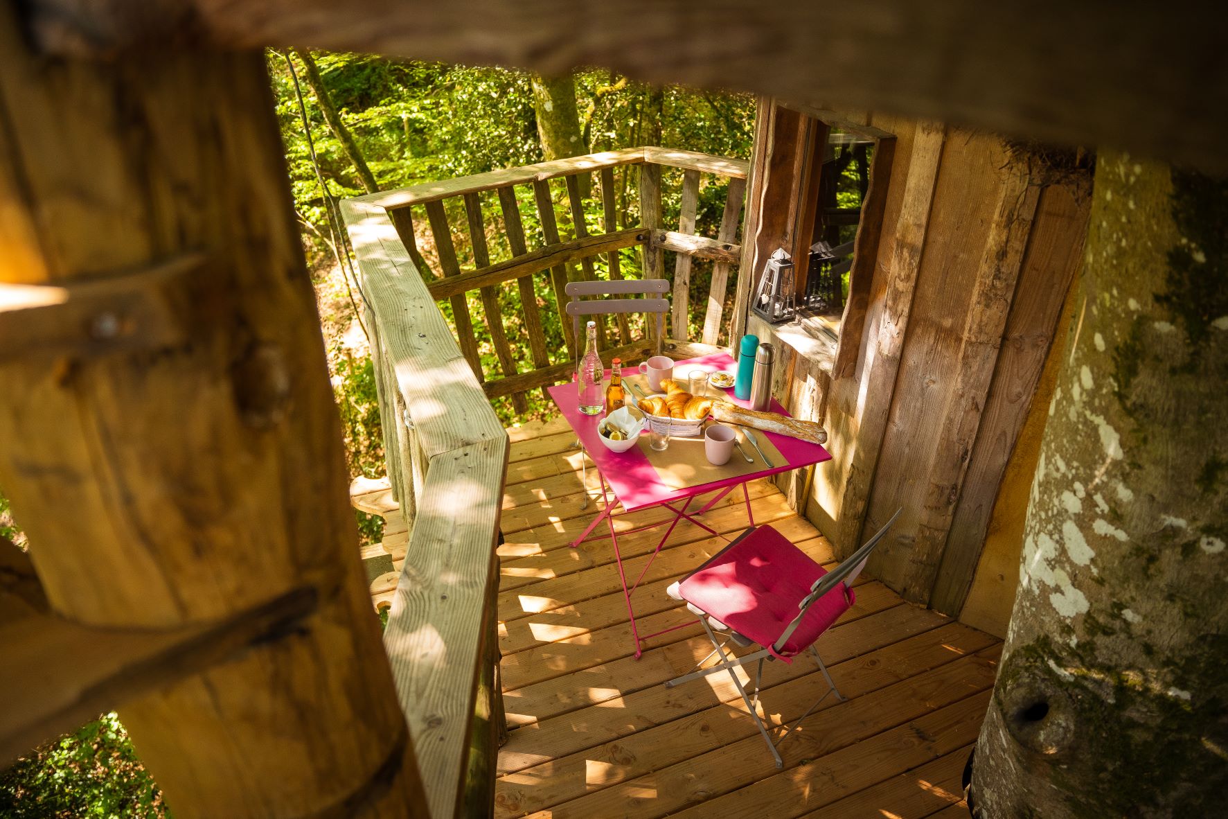 Le Pertuis du Rofo les Chouettes (10) Cabane perchée en Bretagne avec une terrasse en bois et une table colorée.