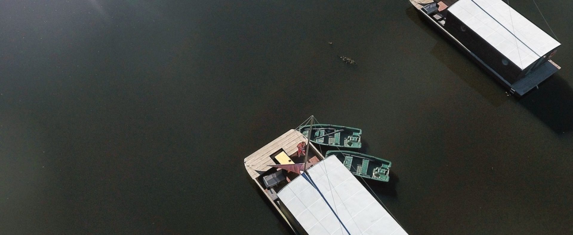 Bungalows flottants sur un lac, entourés de verdure luxuriante et deau calme.