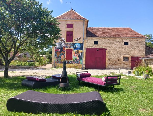 Hébergement insolite en Champagne-Ardenne, avec un bâtiment coloré et un jardin accueillant.