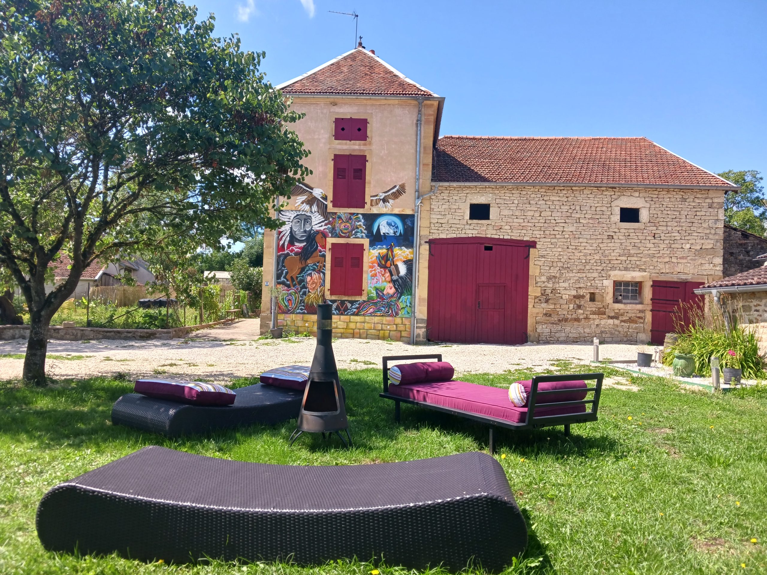 Hébergement insolite en Champagne-Ardenne, avec un bâtiment coloré et un jardin accueillant.