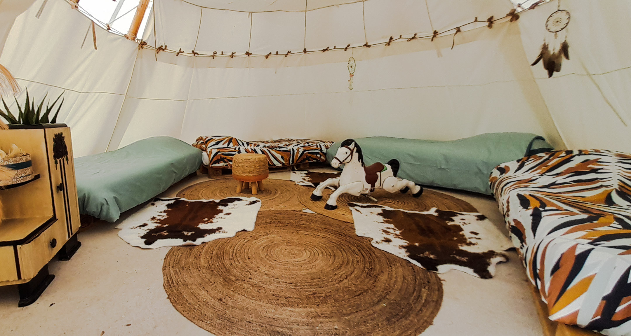 Tipi cosy à Champagne-Ardenne, avec lits colorés et décoration bohème.