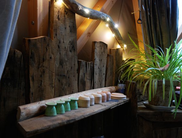 Hébergement insolite en Limousin, intérieur en bois avec pots colorés et plantes.