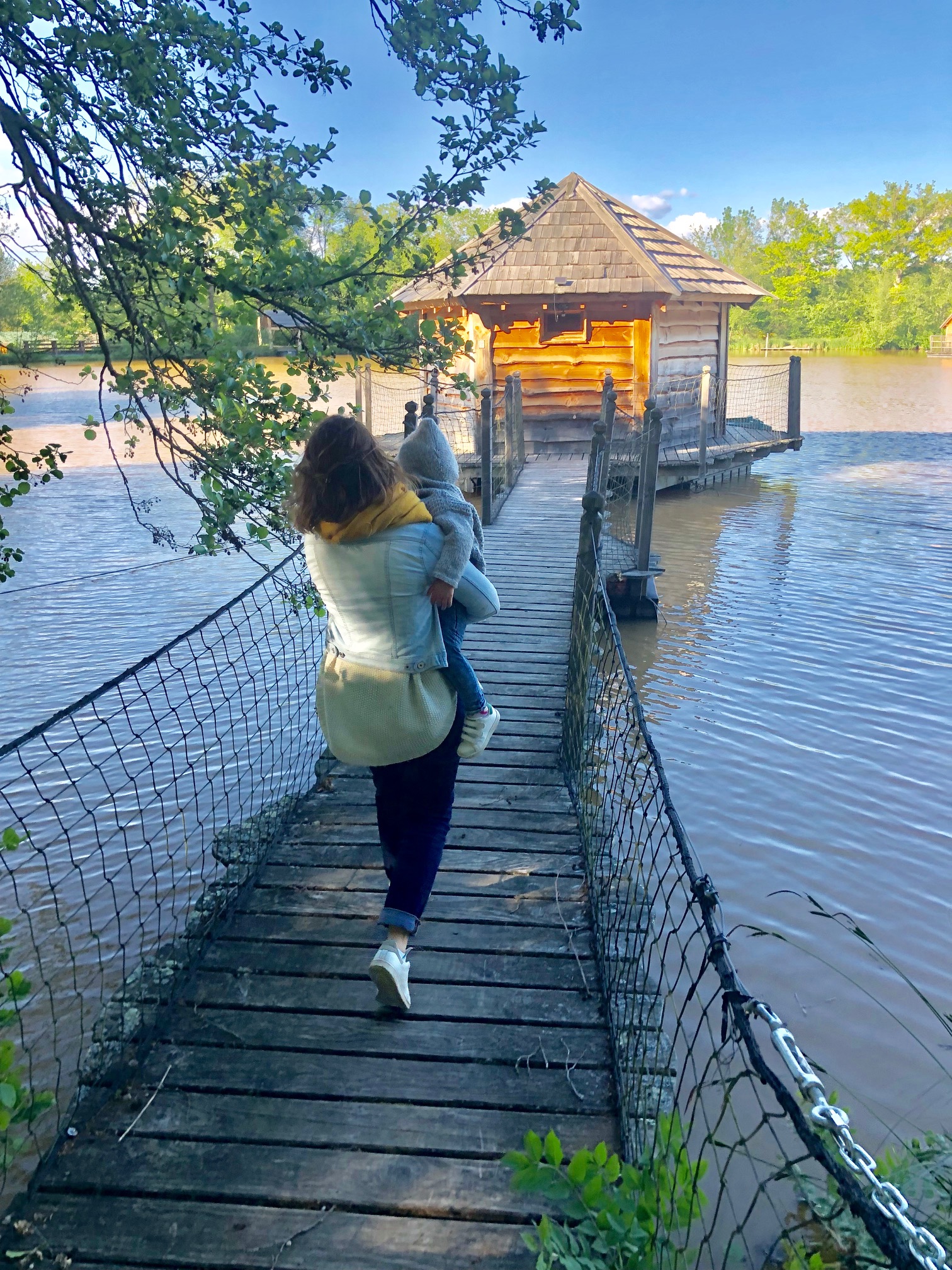 ddld8 Cabane sur pilotis au bord de leau, accessible par un pont en bois. Moment paisible en famille.