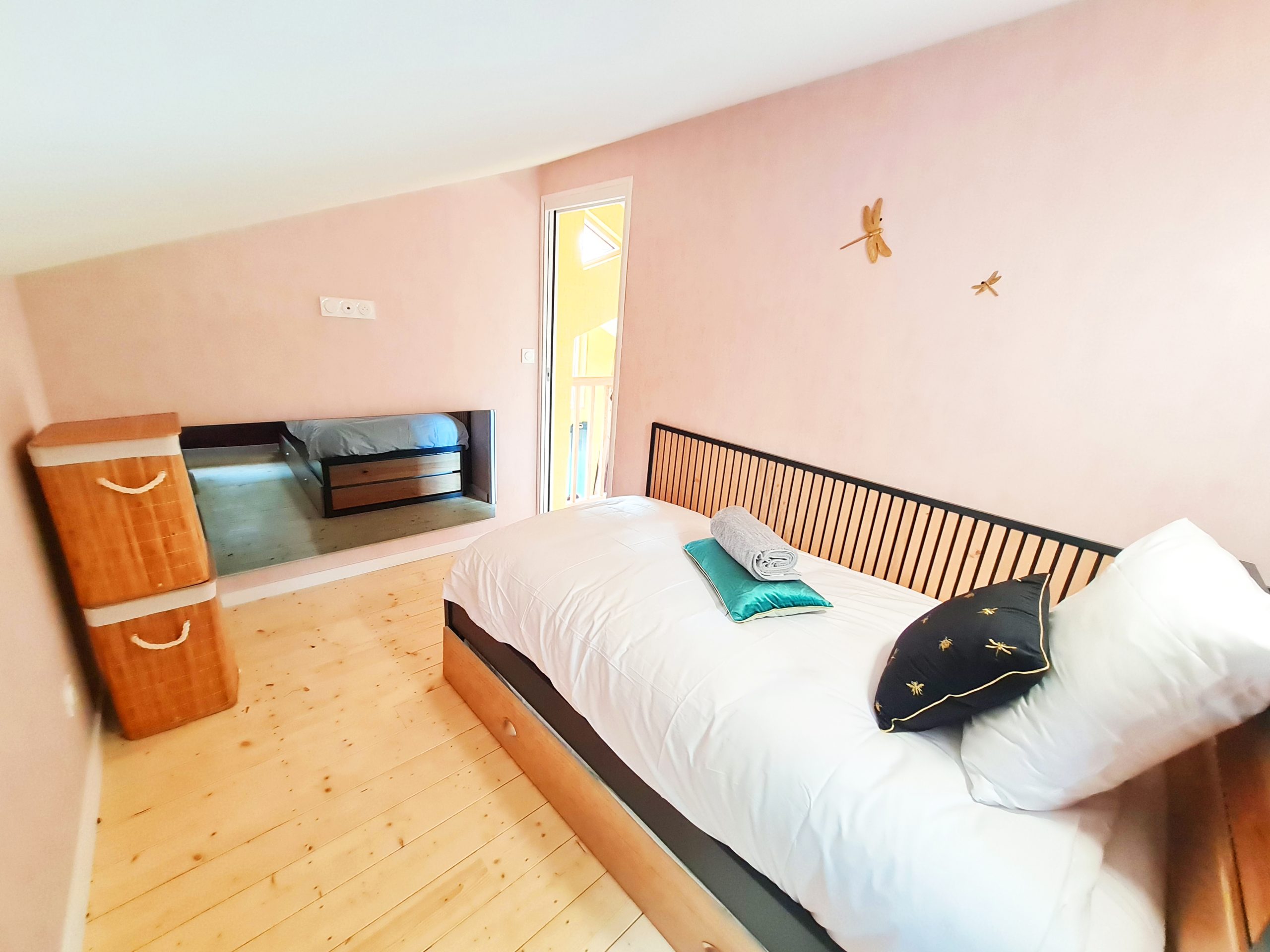 Cabane l'Enchantée - chambre enfant Chambre cosy dans un hébergement insolite, murs roses et lit en bois élégant.