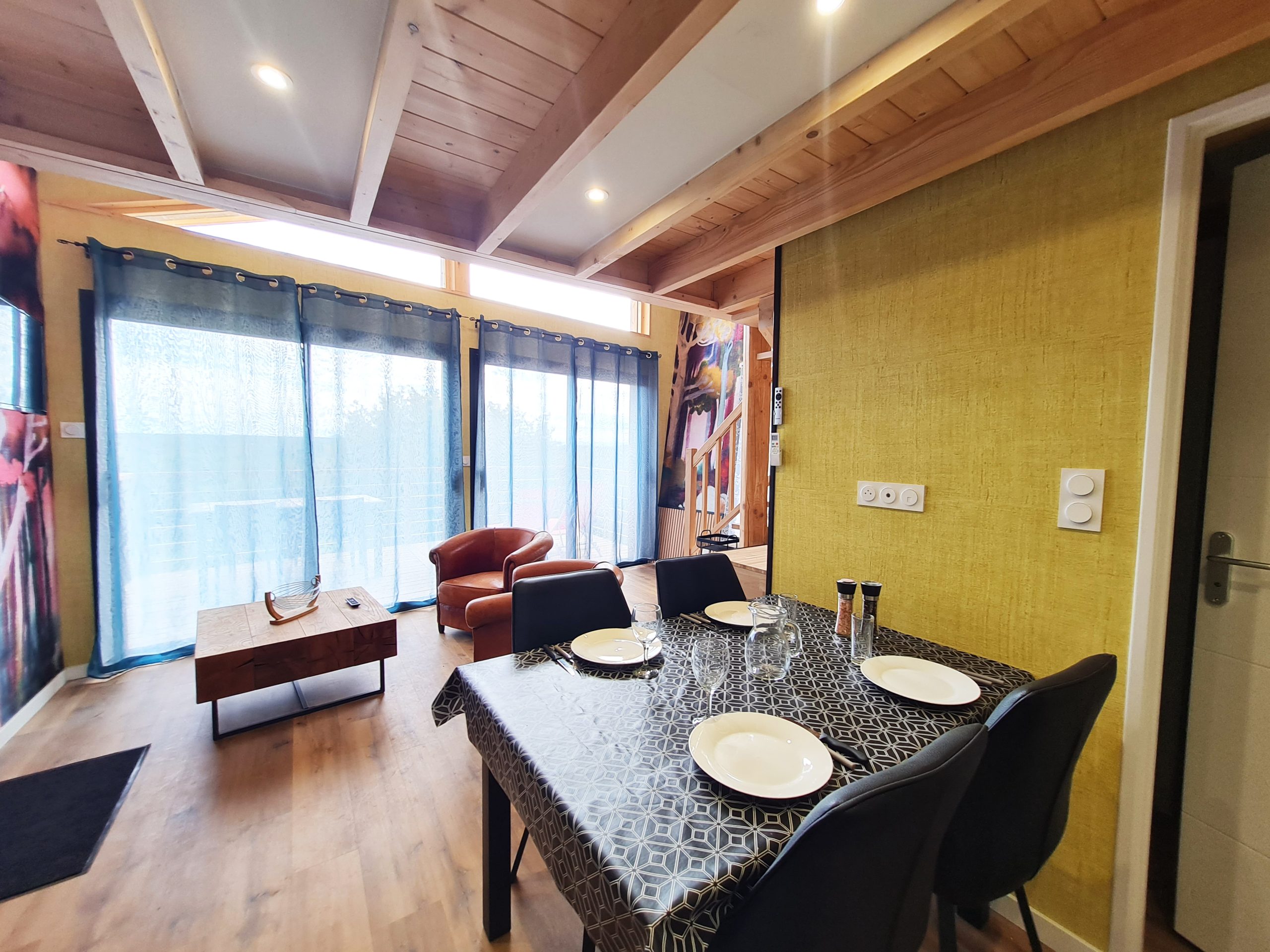 Cabane l'Enchantée - pièce de vie Hébergement insolite à Bourgogne-Franche-Comté, intérieur moderne avec grandes fenêtres.