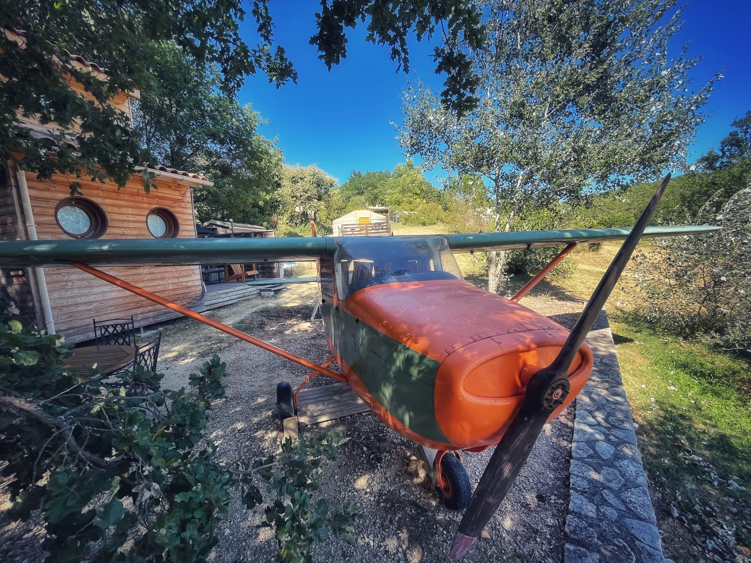avion cessna a barjac 3 aout 2023 Hébergement insolite : un avion transformé en gîte, entouré darbres verdoyants.