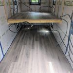 Hébergement touristique : intérieur dune cabane avec un sol en bois clair et des fenêtres.