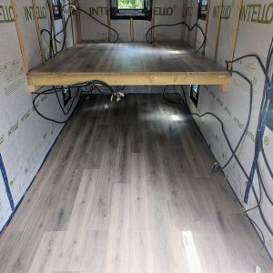 Hébergement touristique : intérieur dune cabane avec un sol en bois clair et des fenêtres.