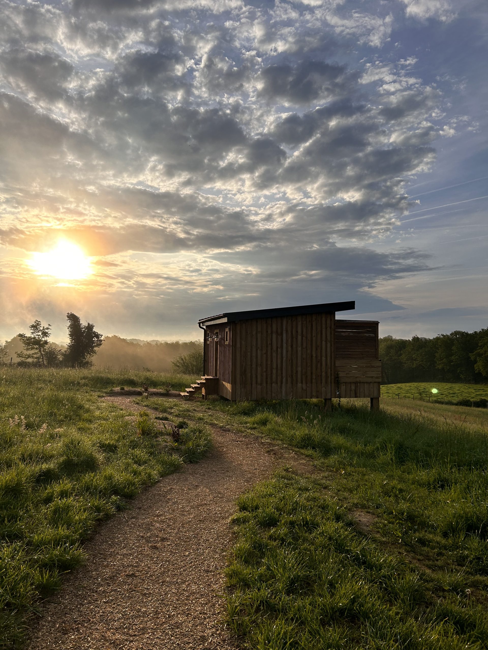 3E Cabane en bois à Aquitaine, baignée par la lumière dorée du coucher de soleil.