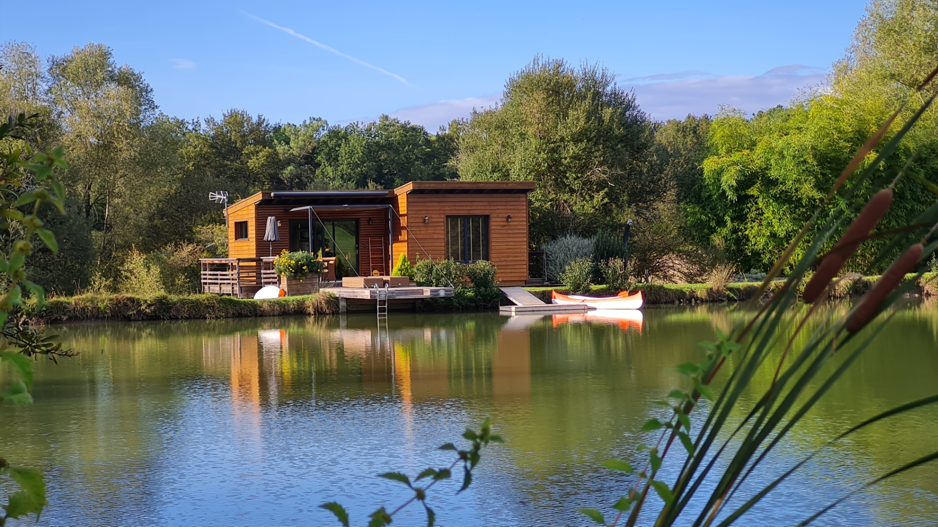 6.10.21 Cabane flottante en Aquitaine, au bord dun lac paisible, entourée de verdure.