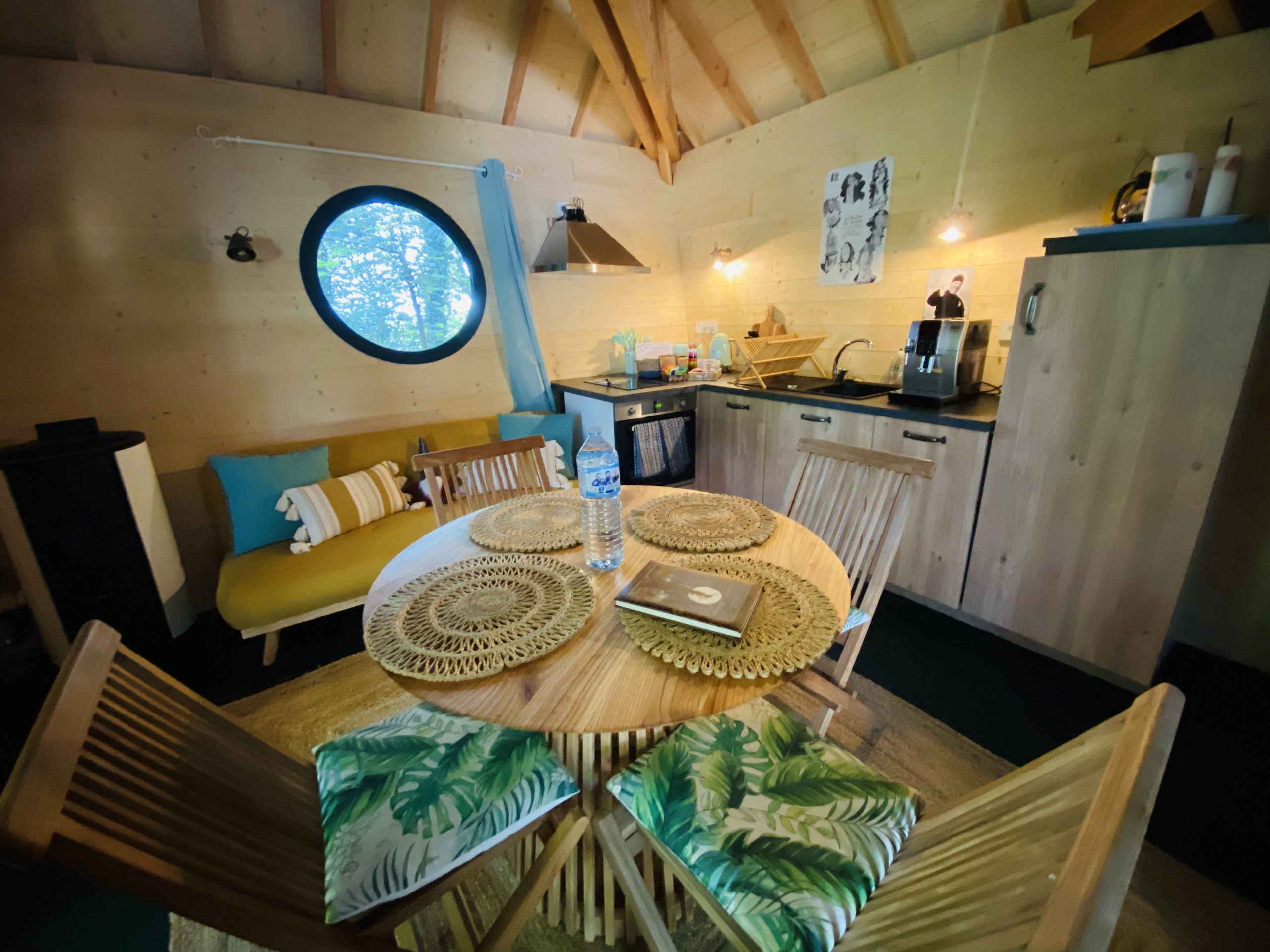 IMG_2757 Cabane en bois en Bretagne, avec un coin cuisine et une grande fenêtre ronde.