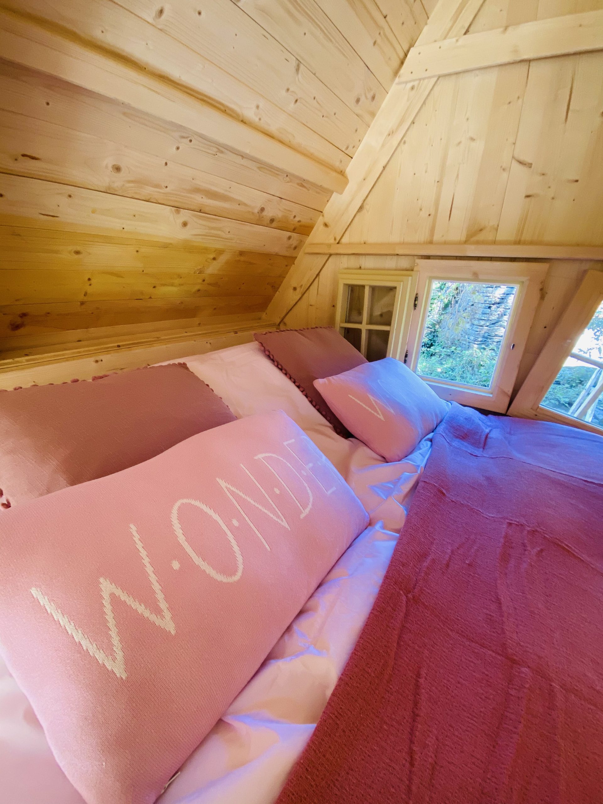 IMG_7762 Cabane en bois en Bretagne, lit douillet avec coussins roses et vue sur la nature.