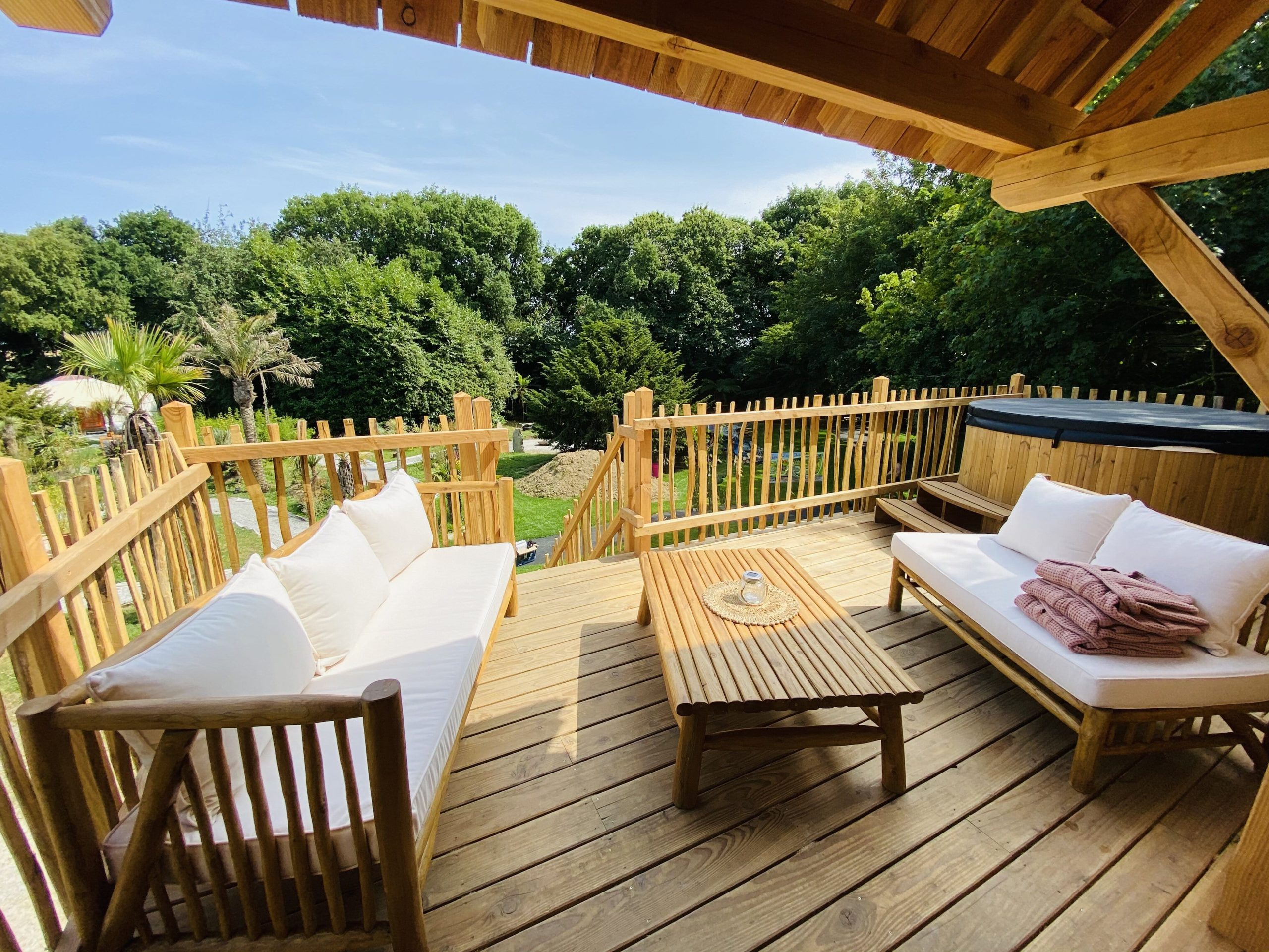 IMG_7914 Hébergement insolite en Bretagne : terrasse en bois avec vue sur la verdure et jacuzzi.