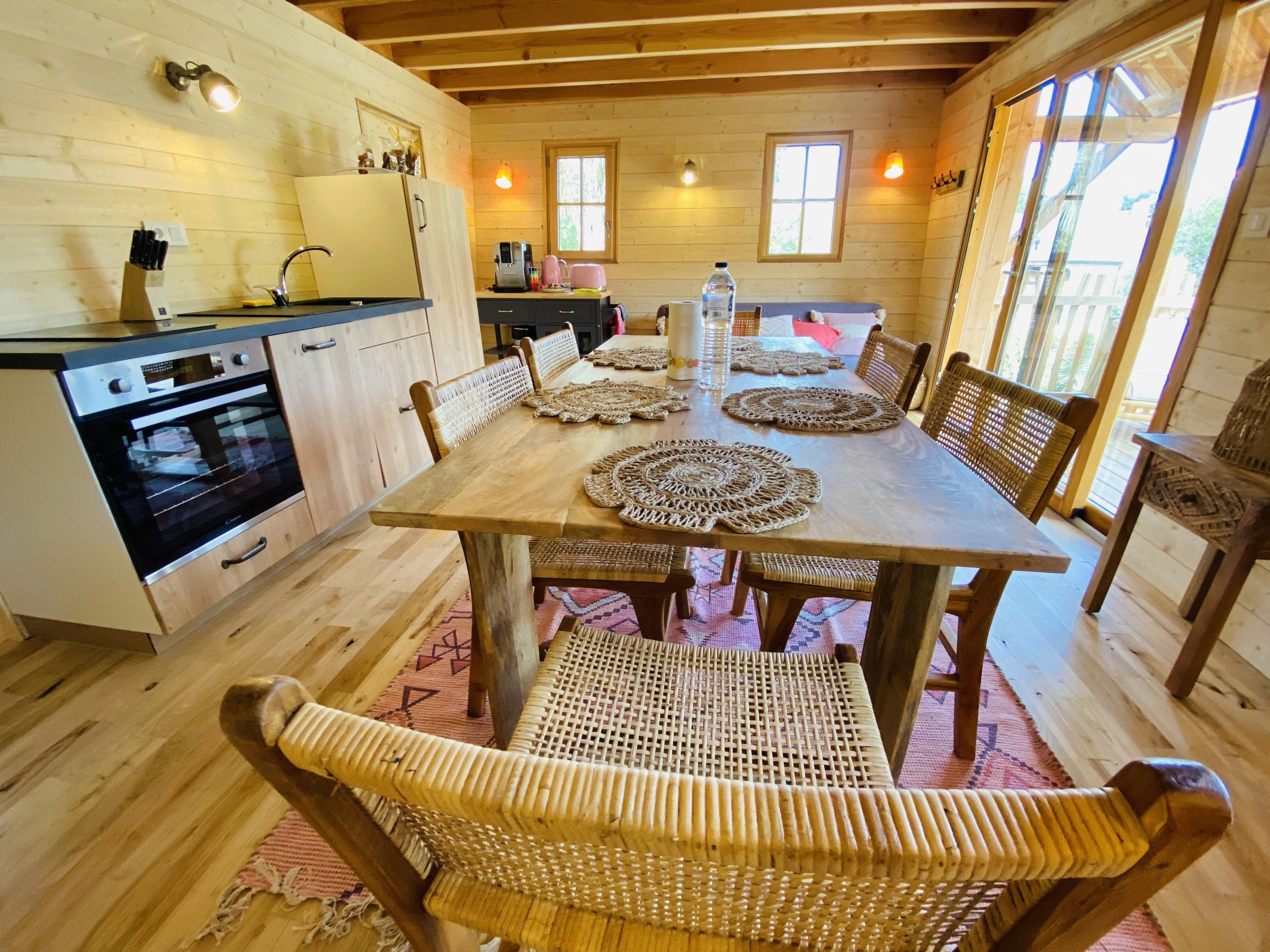 IMG_7919 Cabane en bois en Bretagne, intérieur chaleureux avec table en bois et cuisine équipée.