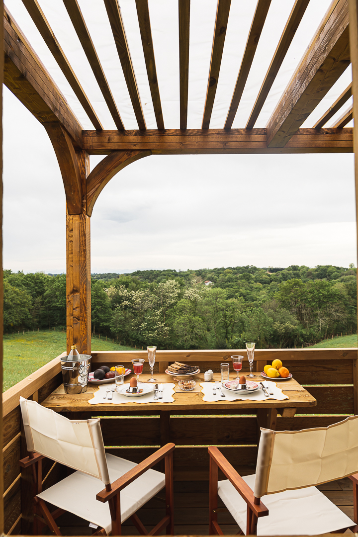 K-HUTES-104 Hébergement insolite en Aquitaine : terrasse en bois avec vue sur la nature verdoyante.