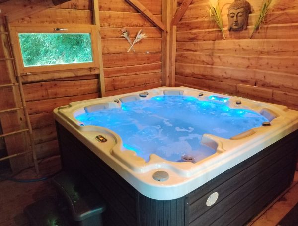 Hébergement insolite en Aquitaine avec jacuzzi lumineux dans un chalet en bois.