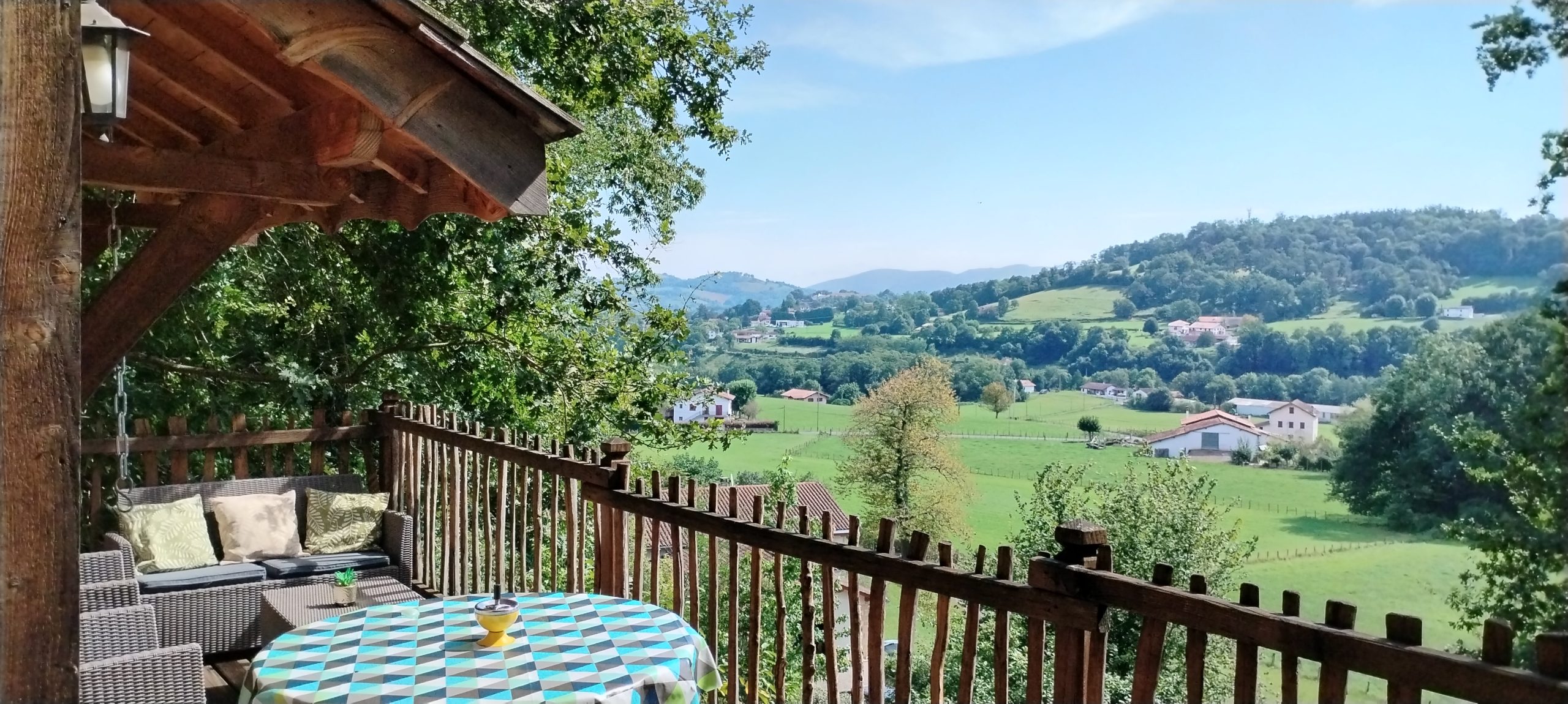 Cabane perchée en Aquitaine avec vue panoramique sur la vallée verdoyante.
