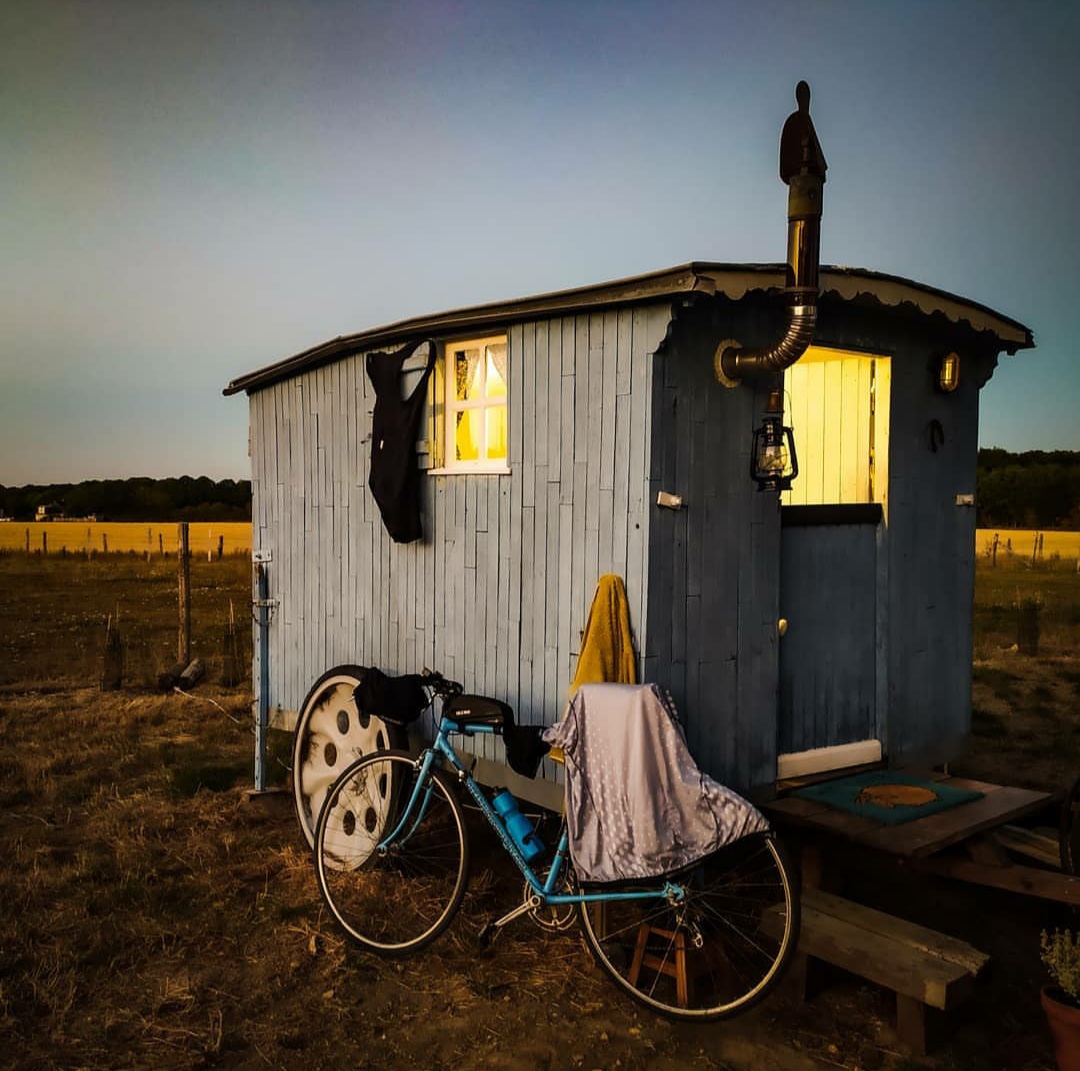 20200812_225824 Charmante roulotte bleue avec une lumière chaleureuse, idéale pour un séjour insolite.